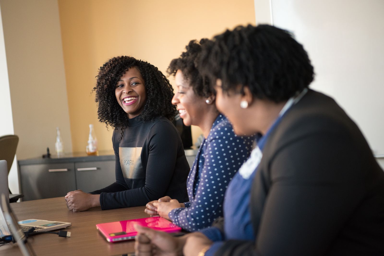Three Black women sharing ideas and laughing together